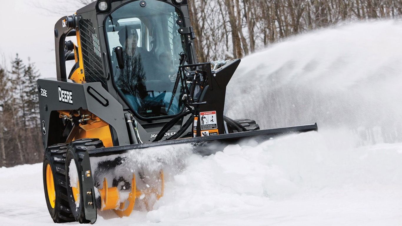 Skid steer with snow blower attachment blowing snow